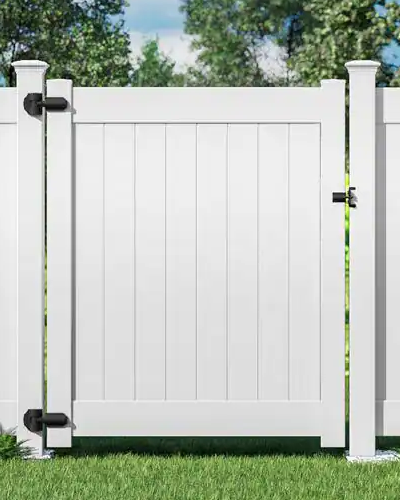 White vinyl walk gate with black hardware in a privacy fence