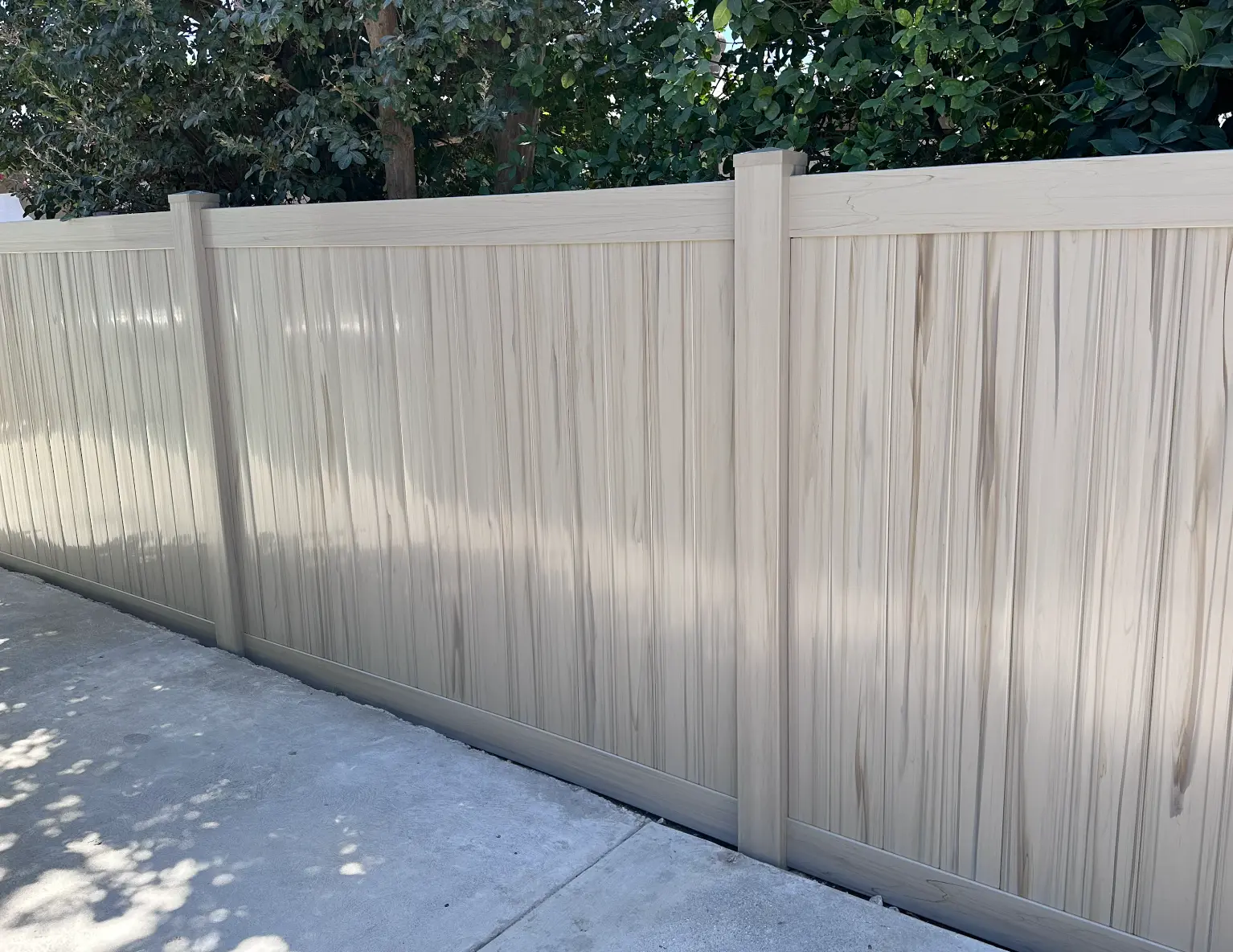 Tan woodgrain colored vinyl privacy fence