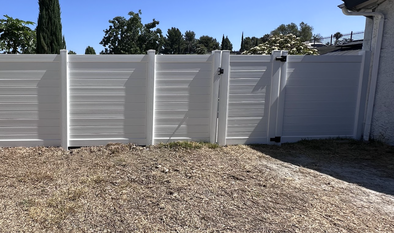 White horizontal plank vinyl privacy fence with matching gate
